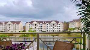 A balcony with a view of a lake and apartment buildings. - WATER VIEW*4 Bedroom/Elevator/5 Star Condo* DISNEY Area (Kissimmee)