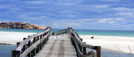 Una playa cerca, sillas reclinables de playa, toallas de playa