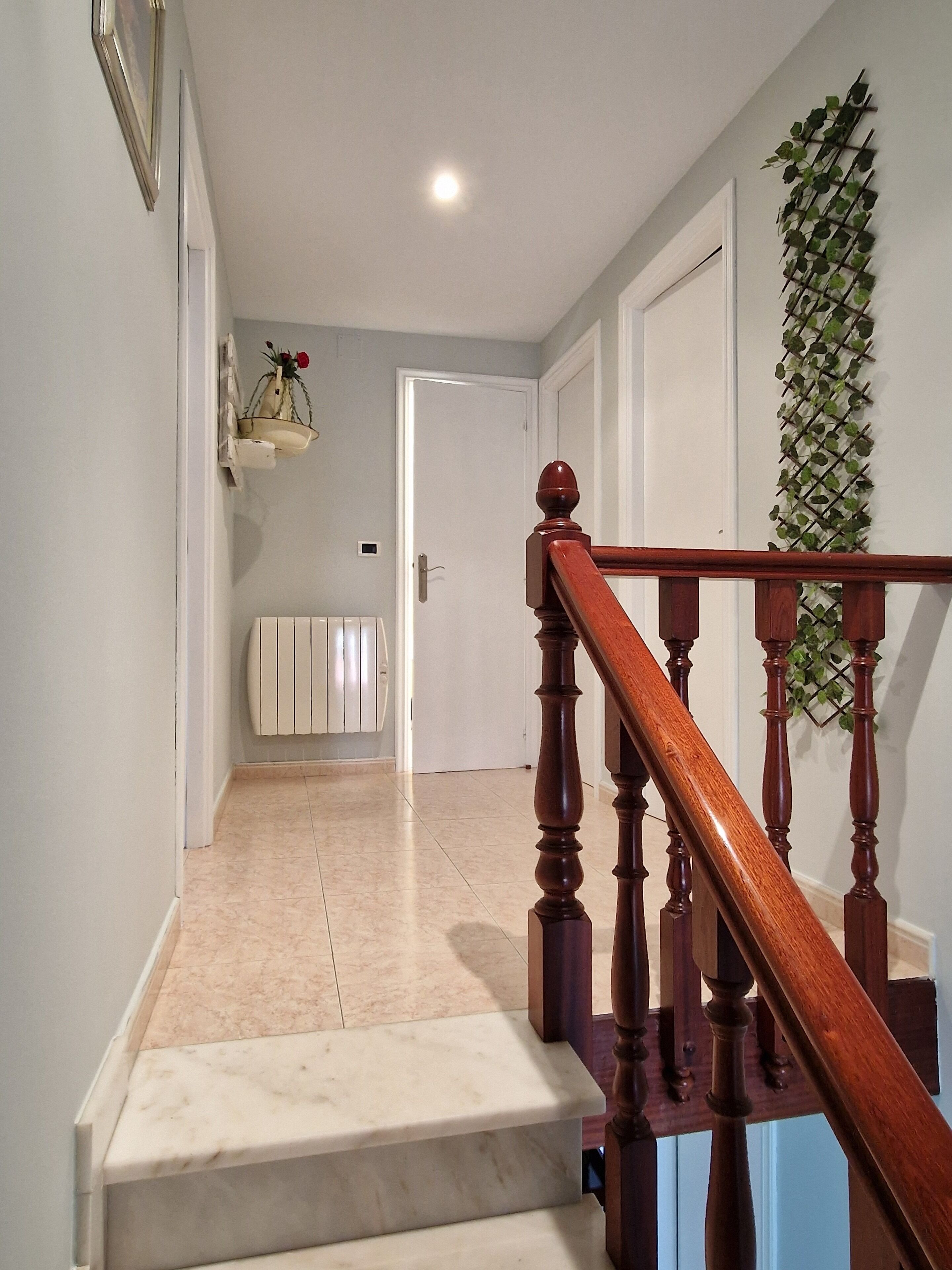 Una escalera con barandilla de madera que lleva a una puerta.