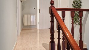 Una escalera con barandilla de madera que lleva a una puerta.