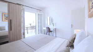 A modern hotel room with a large bed, a desk, and a chair.