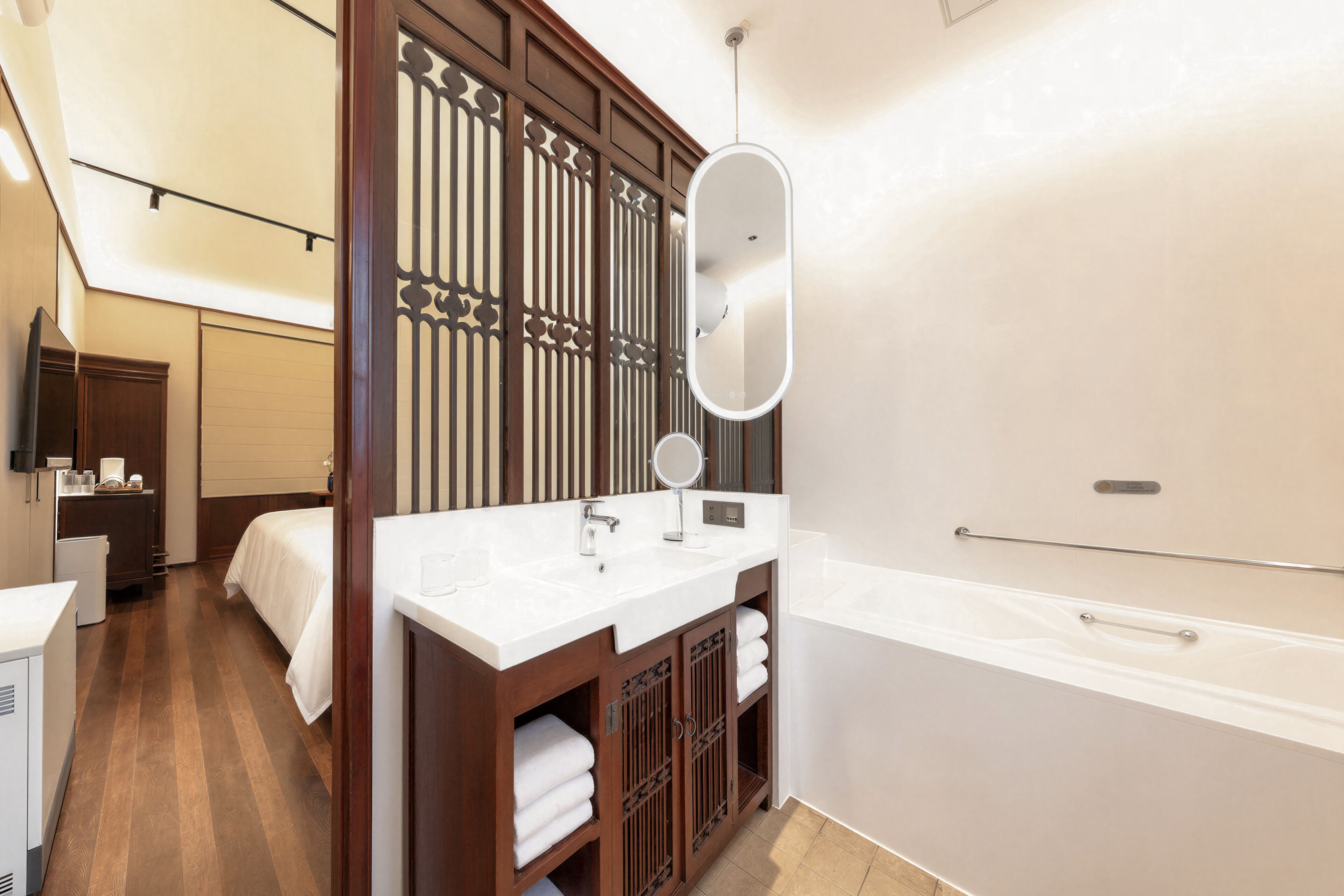 Une salle de bain moderne avec un grand miroir, une baignoire et un meuble-lavabo.