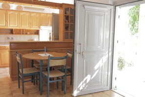 A kitchen with wooden cabinets, a white refrigerator, and a dining table with chairs.