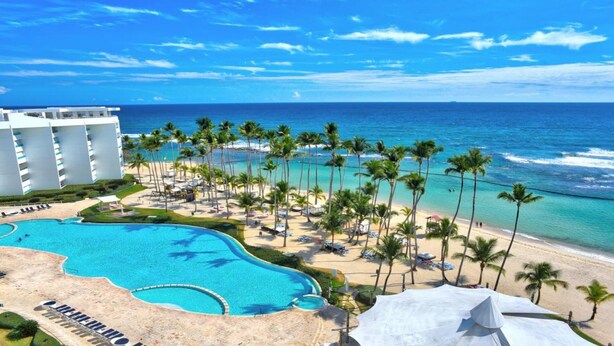 Resort com piscina grande, praia e vista para o oceano.