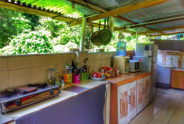A kitchen with a gas stove, a microwave, and various kitchen utensils and appliances.