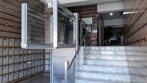 A staircase with marble steps and a glass door leading to a room with patterned walls and a tiled floor. - Torre 6- Family, Wi-fi, Central and 80mt Beach (Quarteira)
