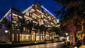 Un hotel de varios pisos con un diseño moderno, que cuenta con balcones y ventanas amplias.