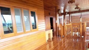 A wooden interior with large windows, a bench, and a decorative gate.