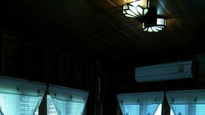 A bed with white linens, a nightstand with a lamp, and a window with a view of the sea.