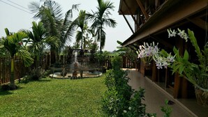 A courtyard with a central water feature, surrounded by palm trees and potted plants.