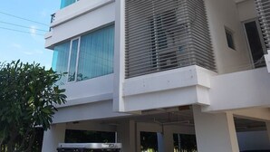 A multi-story building with a modern architectural design, featuring large windows and balconies. - Baan San Dao Hua Hin (Hua Hin)