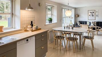 Une cuisine moderne avec un îlot central, des chaises en bois et une table à manger.
