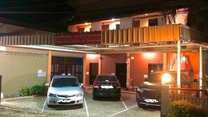 A guesthouse with three cars parked in front, a covered entrance, and a sign indicating it's a guesthouse. - Sandee Place Chomthong (Chom Thong)