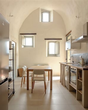 A kitchen with a dining table, chairs, and a built-in oven.