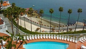 Een resort met zwembad, strand en uitzicht op de oceaan.