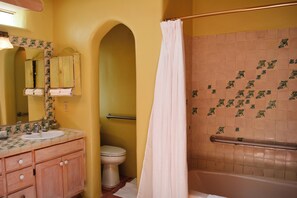 Une salle de bain équipée d’un lavabo, d’un miroir, de toilettes et d’un espace douche.