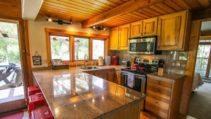 A kitchen with granite countertops, wooden cabinets, a stainless steel oven, and a microwave. - Private Cabin in beautiful Downtown Steamboat! BEST LOCATION in OLD TOWN! (Steamboat Springs)