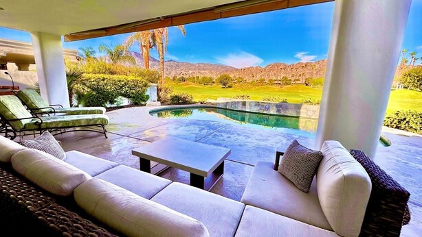 A modern outdoor living area with a pool, seating, and a scenic view of a golf course and mountains. - Breathtaking views from your private pool & spa in PGA West: 3 BD/STR #065869 (La Quinta)