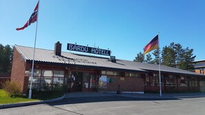 A BARDU HOTEL with a clear sign, a flagpole, and a visible entrance. - Bardu Hotell (Bardu)