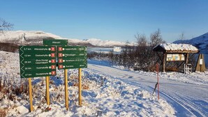 A directional signpost in a snowy landscape with a clear sky. - Bardu Hotell (Bardu)