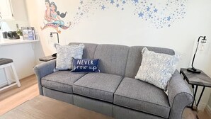 A modern living room with a grey sofa, a wooden coffee table, and a patterned rug. - Las Palmas Resort #1627 | All-Inclusive Amenities (Saint George)