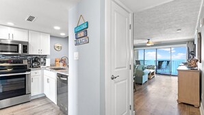 Een moderne keuken met roestvrijstalen apparatuur, een eethoek met uitzicht, en een balkon met een panoramisch zicht.