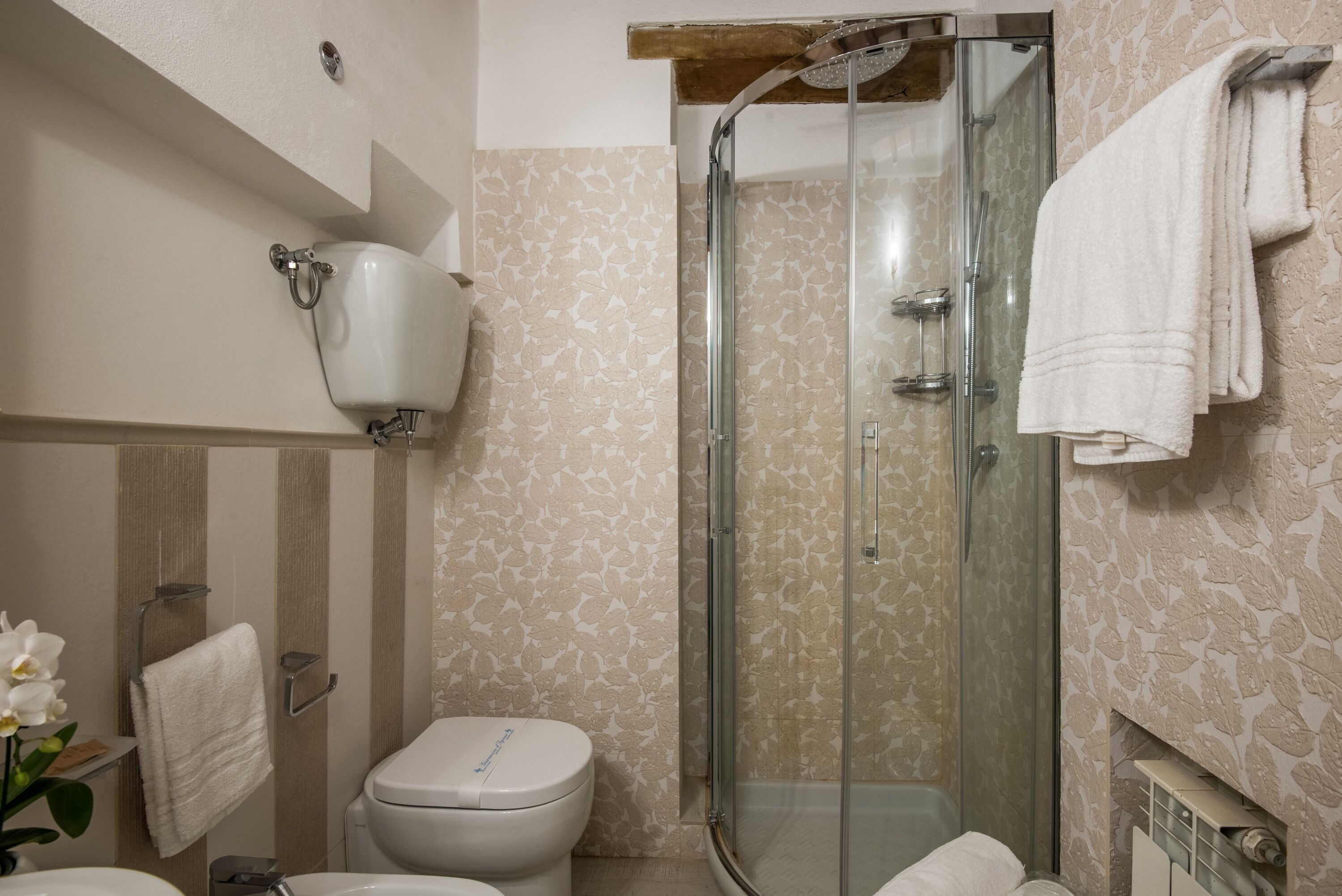 Une salle de bain équipée de toilettes, d’un lavabo, d’une douche et d’un porte-serviettes.