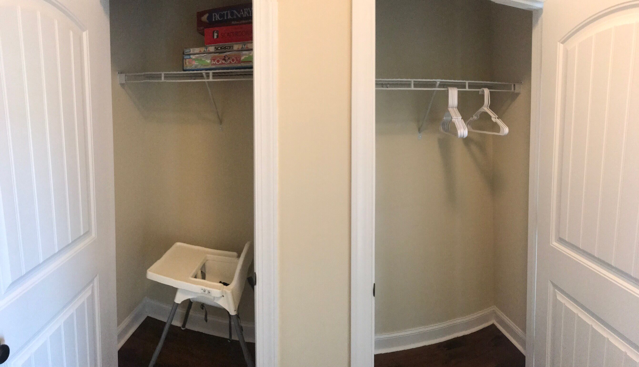 A small, narrow closet with a white shelf holding board games and a white hanger rod.