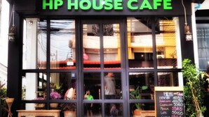 The exterior of HP House Cafe with a black and white facade, large windows, and a visible menu board outside. - HP House Cafe' (Chiang Mai)