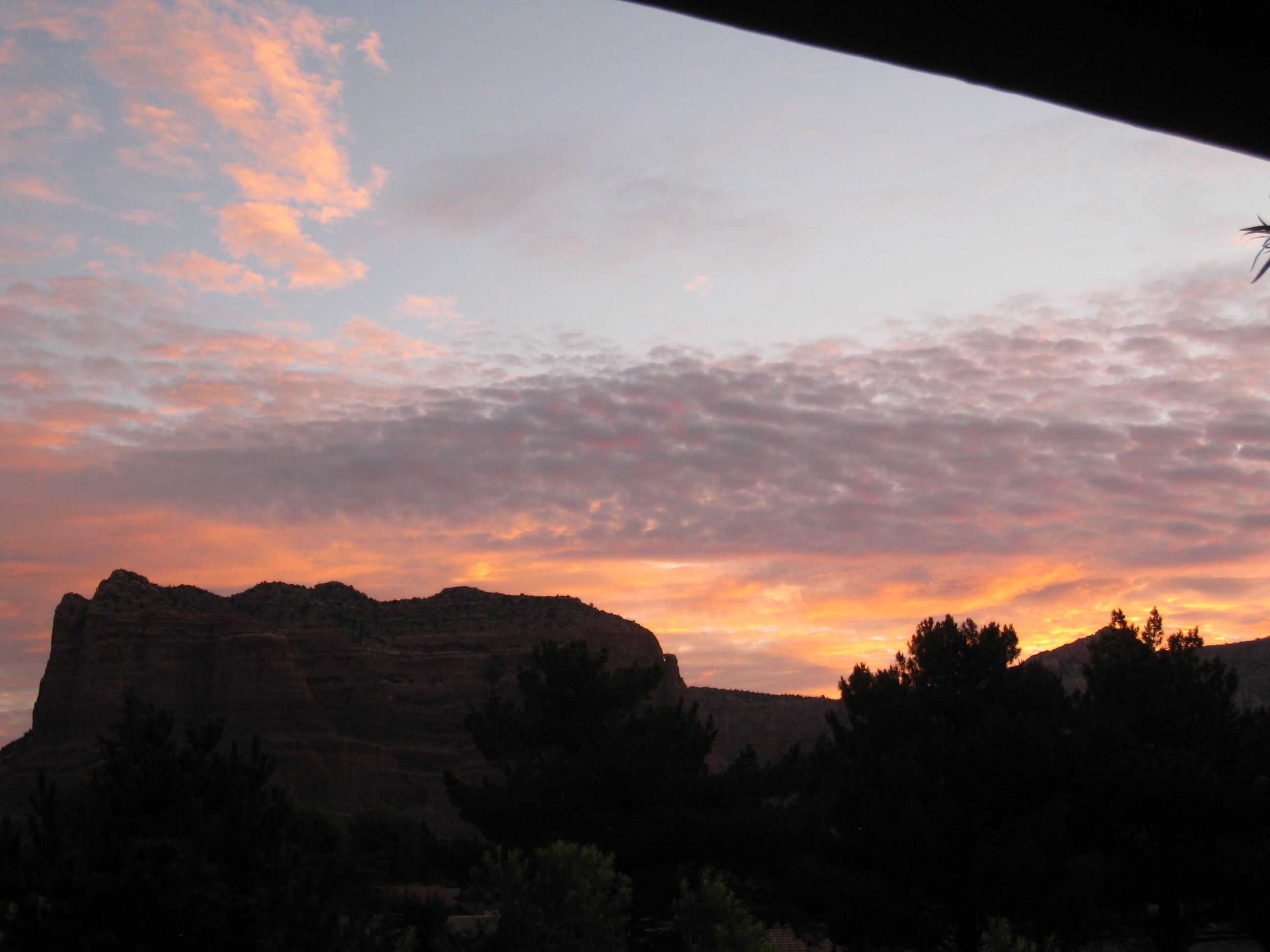 A sunset over a mountainous landscape with a clear sky.