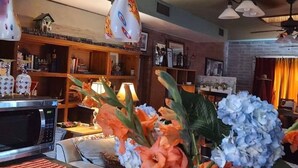 A kitchen with a microwave, a vase with flowers, and a striped rug. - Knightly's Ranch Guesthouse  (Tucson)