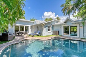 A residential property with a swimming pool, outdoor seating, and a covered patio area. - Unwind Sunshine | Heated Pool | 1.5 Blocks to Beach | Complimentary Bikes (Holmes Beach)