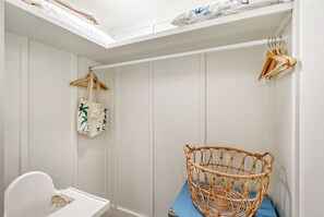 A bathroom with a white sink, a white toilet, a wicker basket on a blue mat, and a towel rack with a white towel and a bag. - Unwind Sunshine | Heated Pool | 1.5 Blocks to Beach | Complimentary Bikes (Holmes Beach)