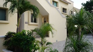 Un bâtiment à la façade beige, doté de nombreuses fenêtres et d’un escalier menant à un étage supérieur.