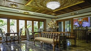 A spacious lobby with a reflective floor, a wooden bench, patterned chairs, and a large chandelier. - White Boutique Hotel and Spa (Chiang Mai)