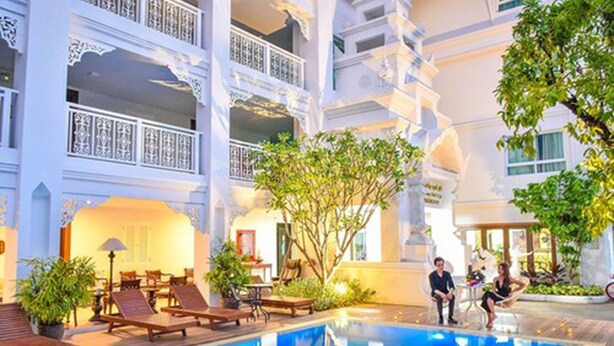 A hotel with a pool, outdoor seating, and a multi-story building with balconies. - White Boutique Hotel and Spa (Chiang Mai)
