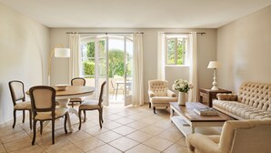 A spacious living room with a dining area, a sofa, and a coffee table. - Golf Resort & Country Club Saint-Tropez (Gassin)