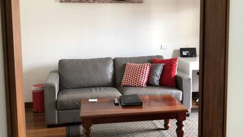 Deluxe Suite, 1 Queen Bed, Ensuite, Poolside | Living room | Flat-screen TV