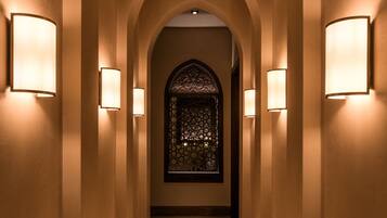 A hallway with arched ceilings and wall-mounted lights.