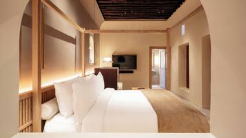 Habitación de hotel moderna con una cama grande, un televisor de pantalla plana y techo de madera.
