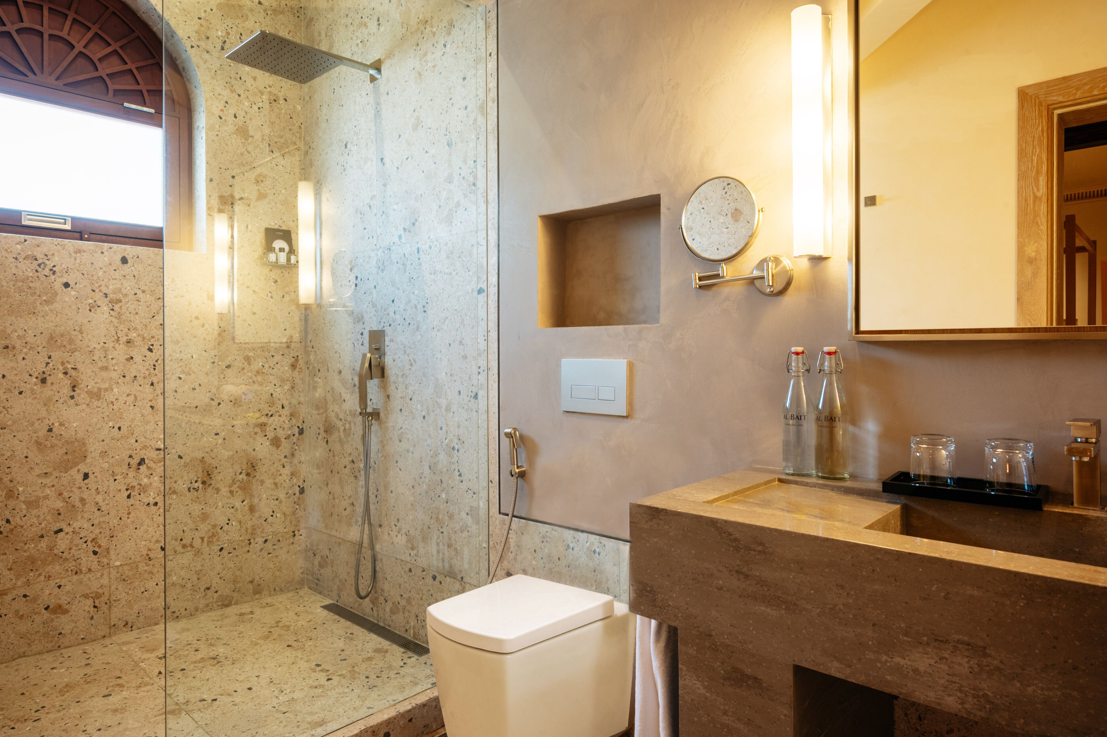 A modern bathroom with a shower, toilet, and sink.