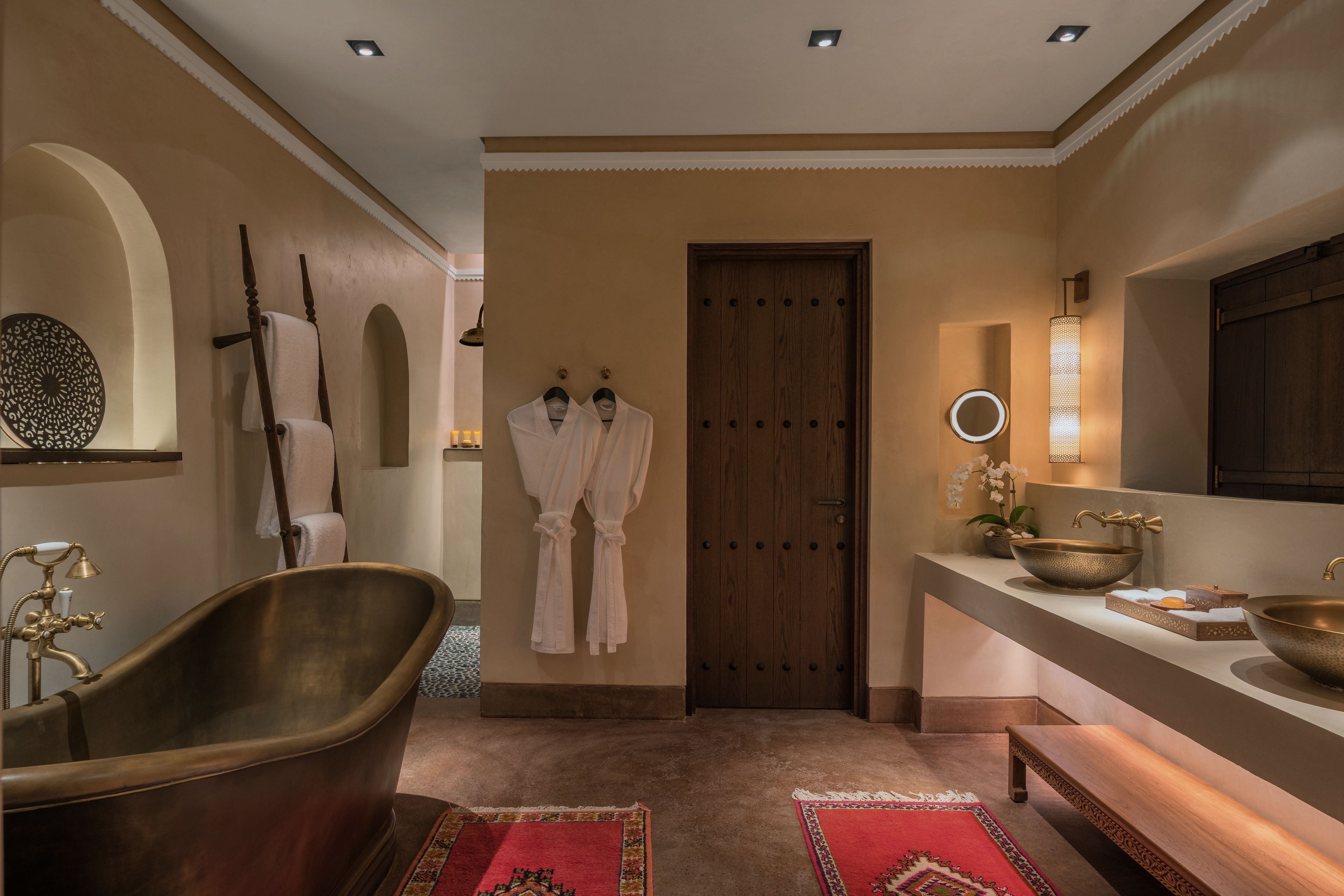 A bathroom with a freestanding bathtub, a wooden door, and a vanity with a large bowl sink.