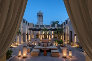 Un patio con zona de estar, faroles y vistas a un edificio con cúpula.
