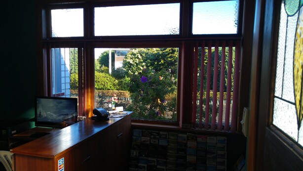 A room with a desk, a computer, and a window with blinds. - Redwood Lodge Motel (Levin)