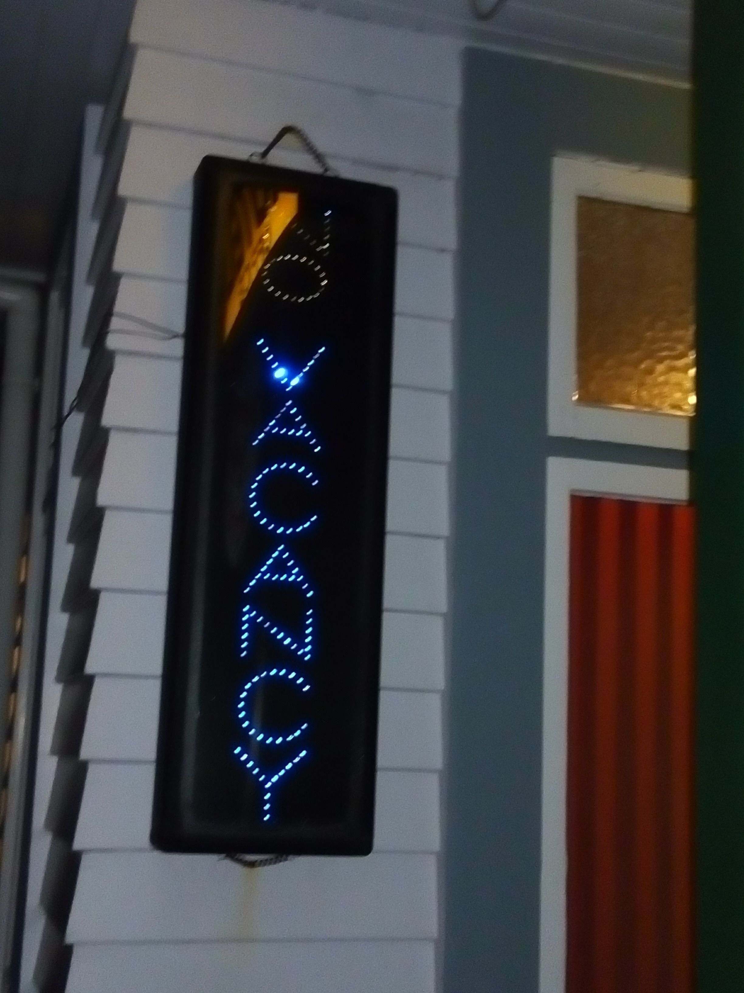A neon sign with the word "VODKA" in blue lights on a building facade.