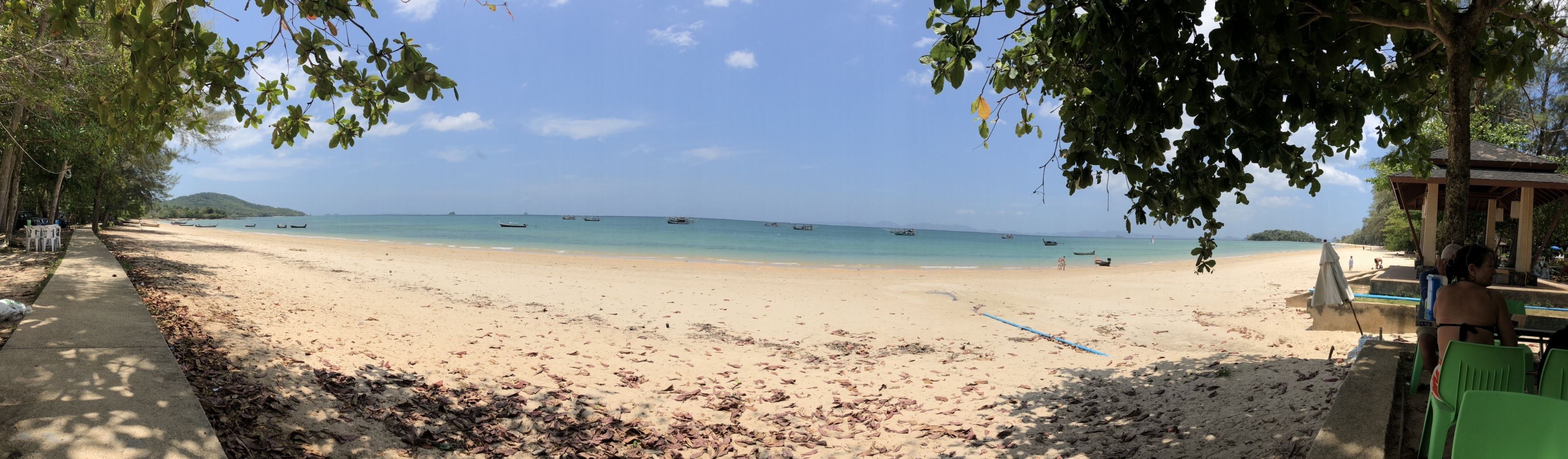 Une plage avec des bateaux, un espace de repos abrité et un sentier.