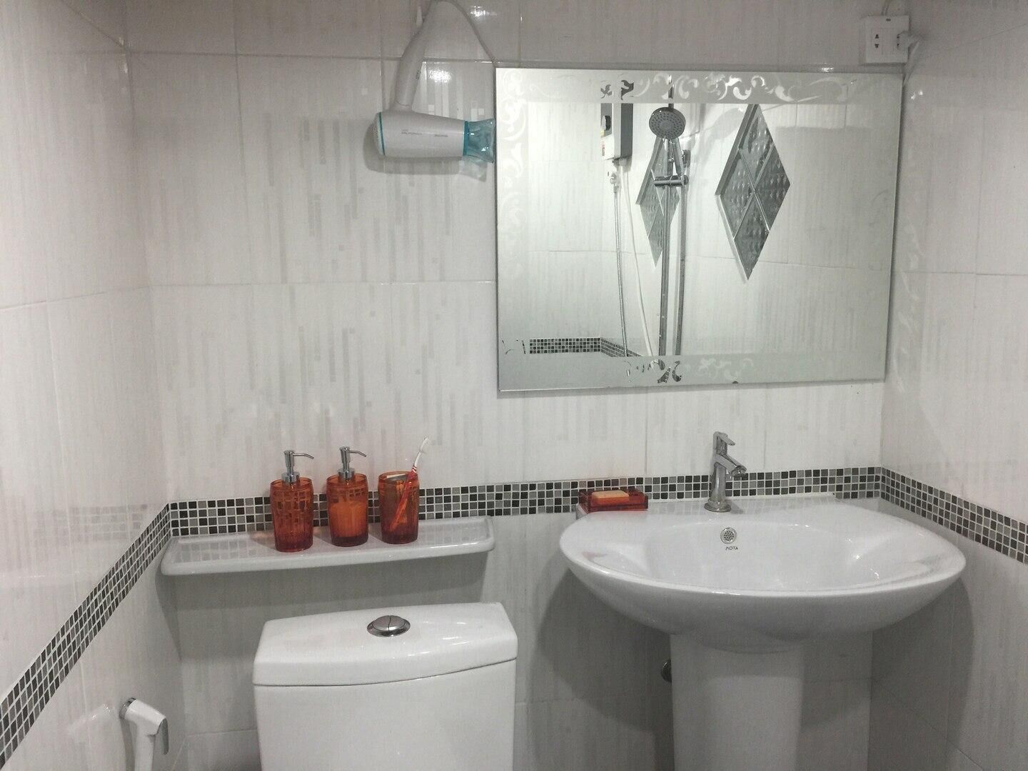 A bathroom with a toilet, sink, and shower.