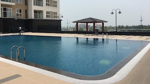 A swimming pool with a pergola and a building in the background. - Hometel Newlife Ha Long (Bai Chay)