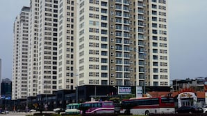 A high-rise residential building with multiple balconies and a modern architectural design. - Hometel Newlife Ha Long (Bai Chay)