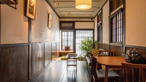 Perinteinen japanilainen ravintola, jossa on puulattia, matala pöytä ja penkki.